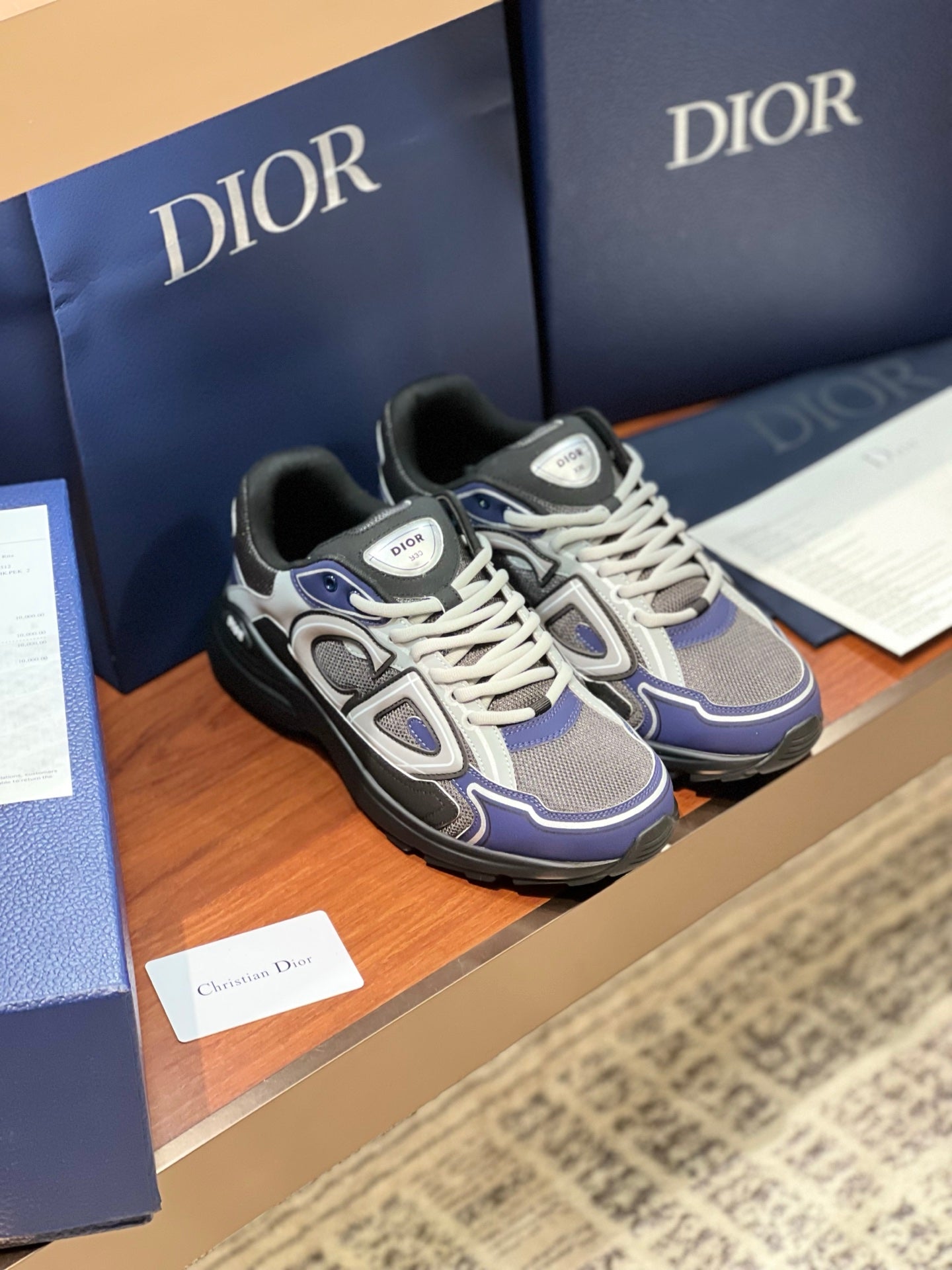 Lace-up chunky sneakers in gray, navy, and white with black outsole and logo patch.