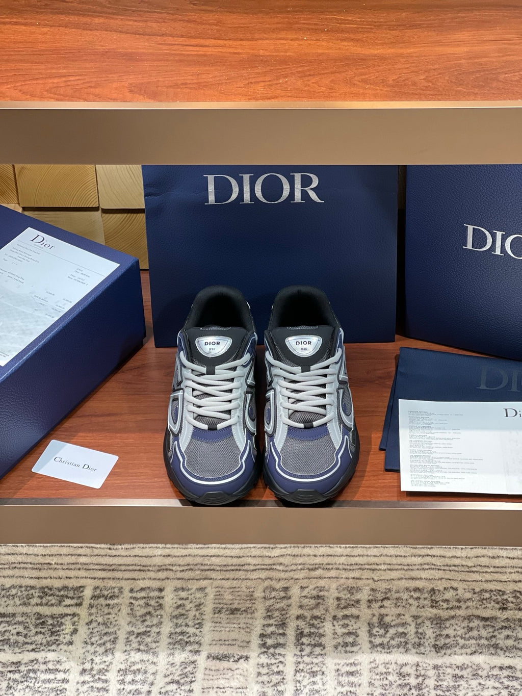 Women’s lace-up sneakers, gray with navy and white panels, black sole.