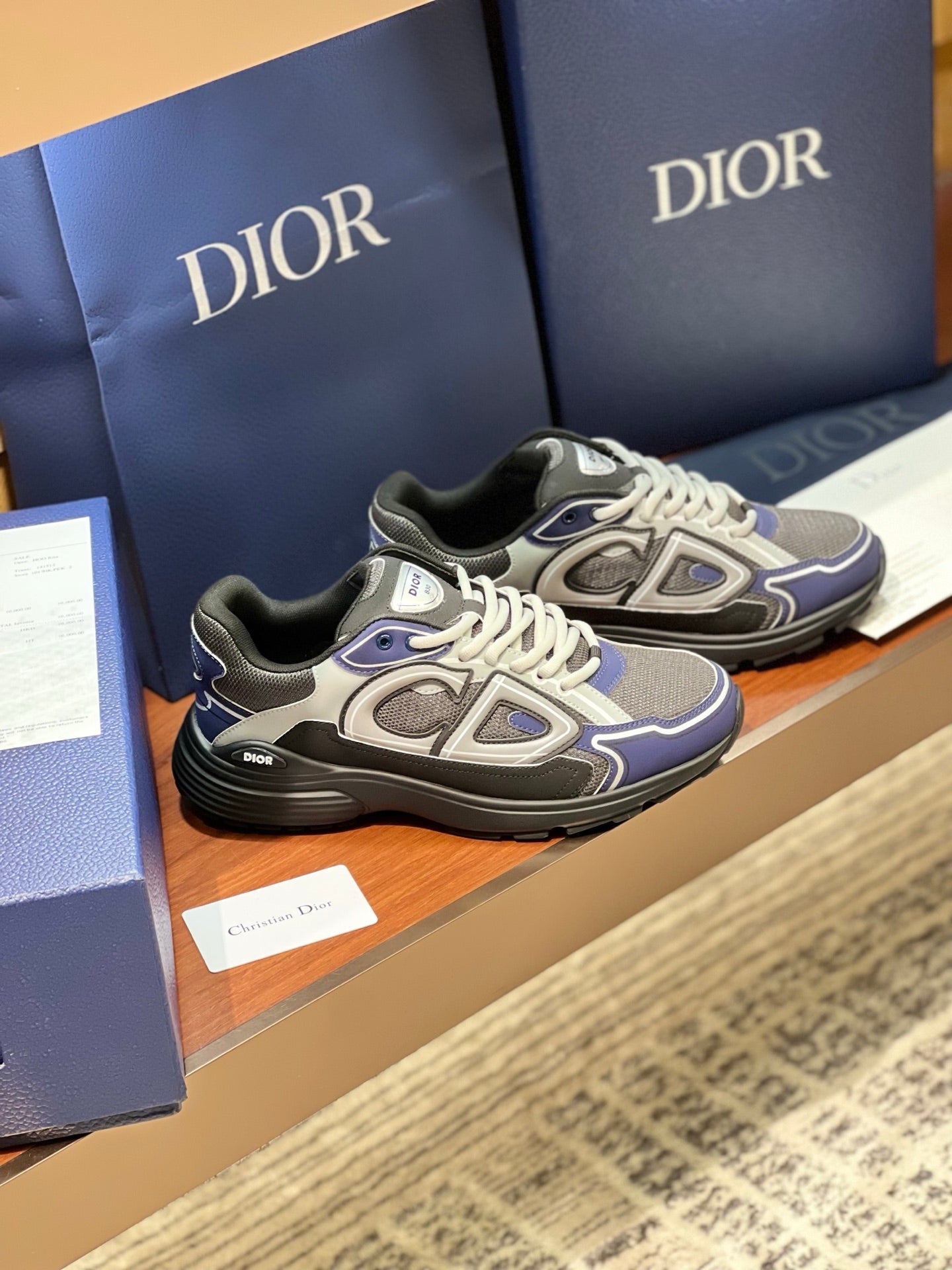 Lace-up chunky sneakers in gray and navy with white laces and logo detail.