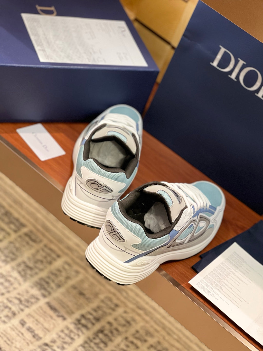 Dior women's sneakers from heel view, light blue and white with rear logo patch