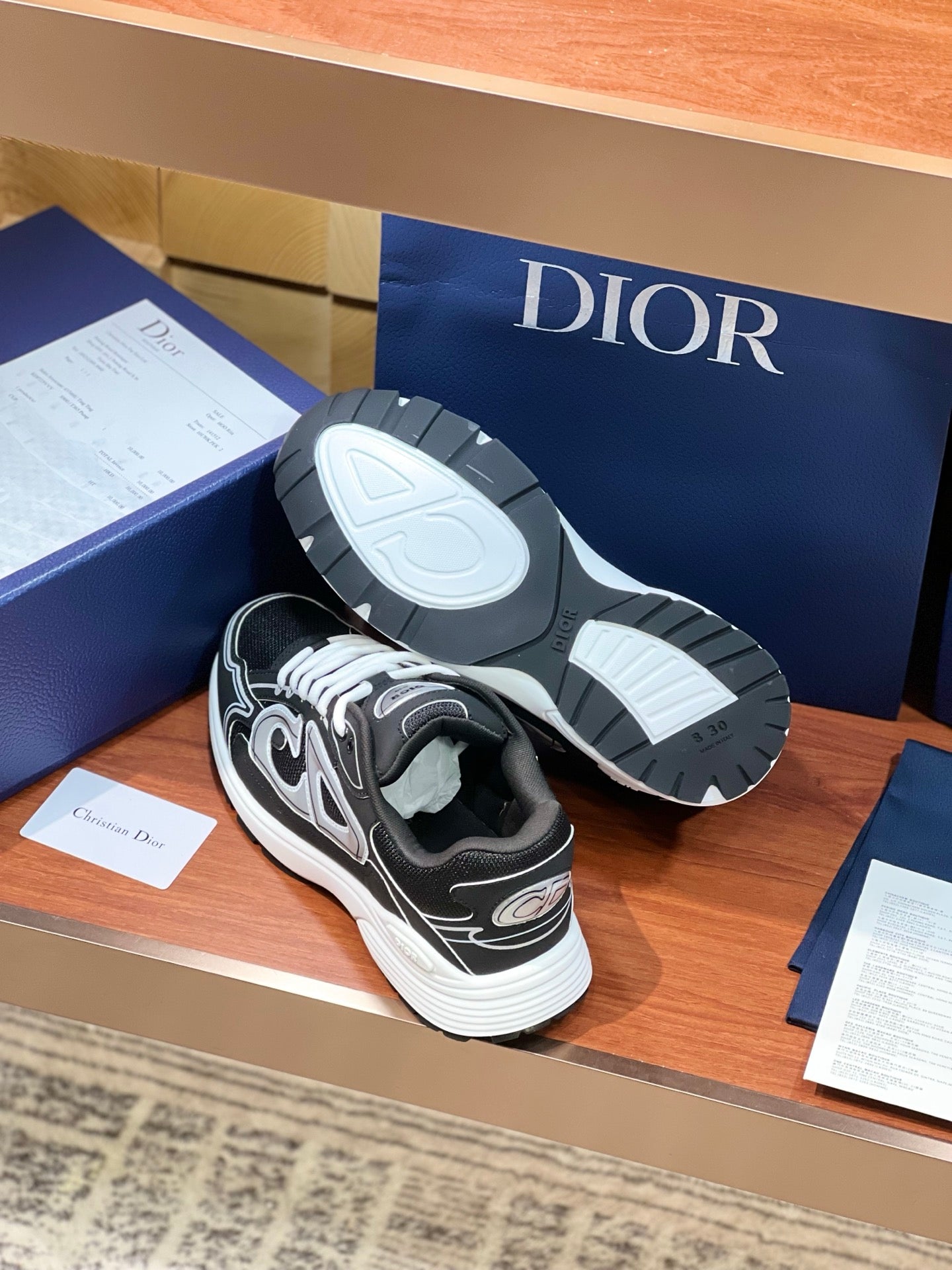 Dior ladies sneakers with soles shown, black uppers and white tread detail