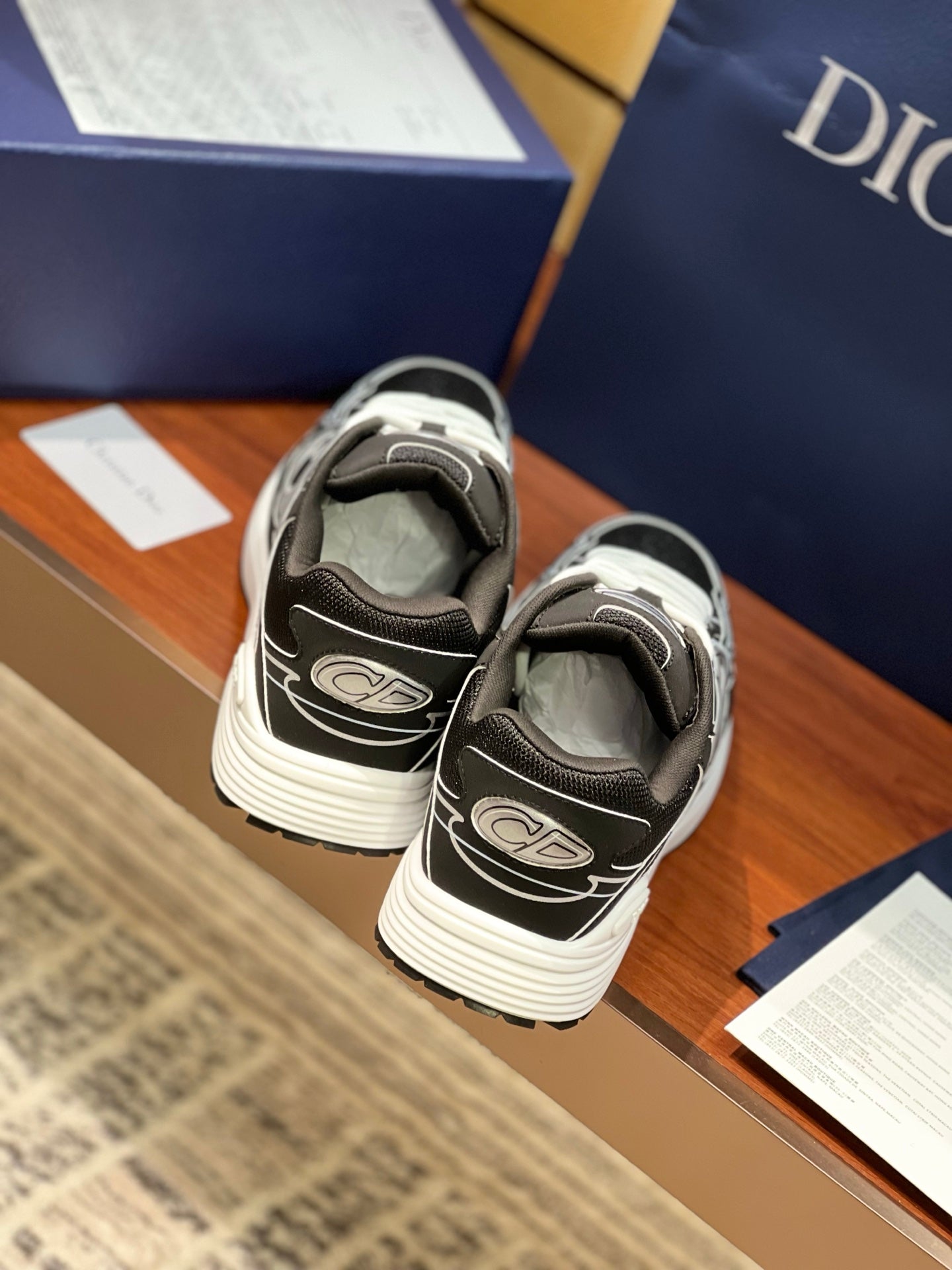 Dior ladies sneakers back view, black uppers with white logo and ribbed sole