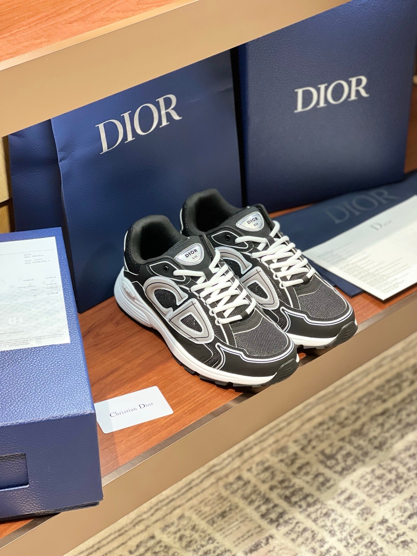 Dior ladies lace-up sneakers on display, black mesh with white laces and trim
