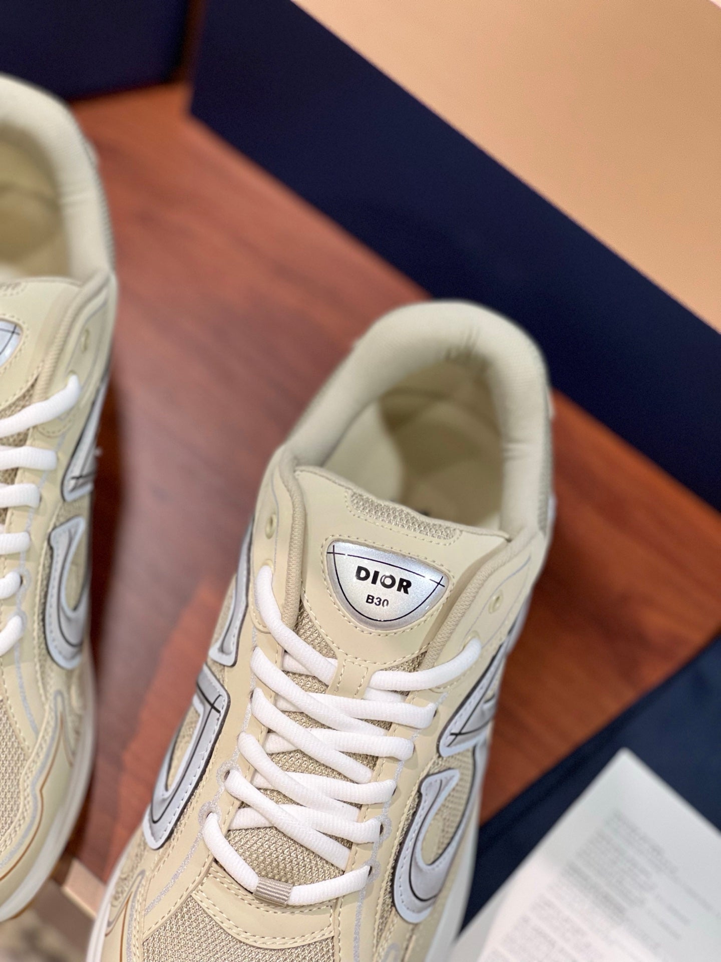 Beige sneaker tongue patch with Dior logo and white laces