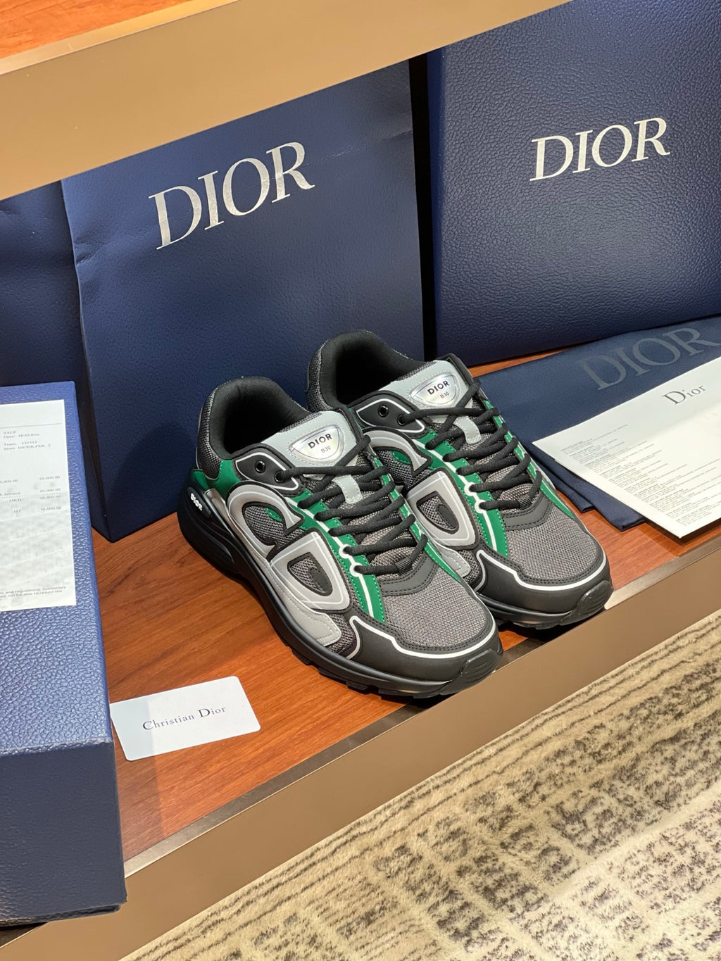 Dior ladies sneakers side view, grey upper with green trim and black outsole