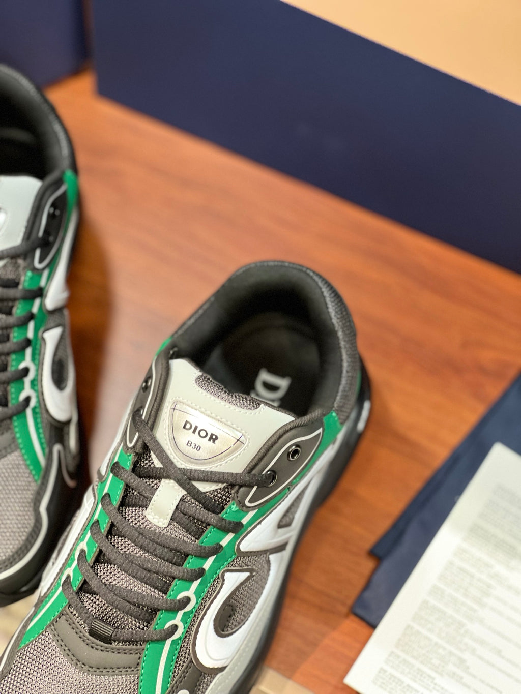 Dior ladies sneakers close-up, grey knit with green laces and logo strap
