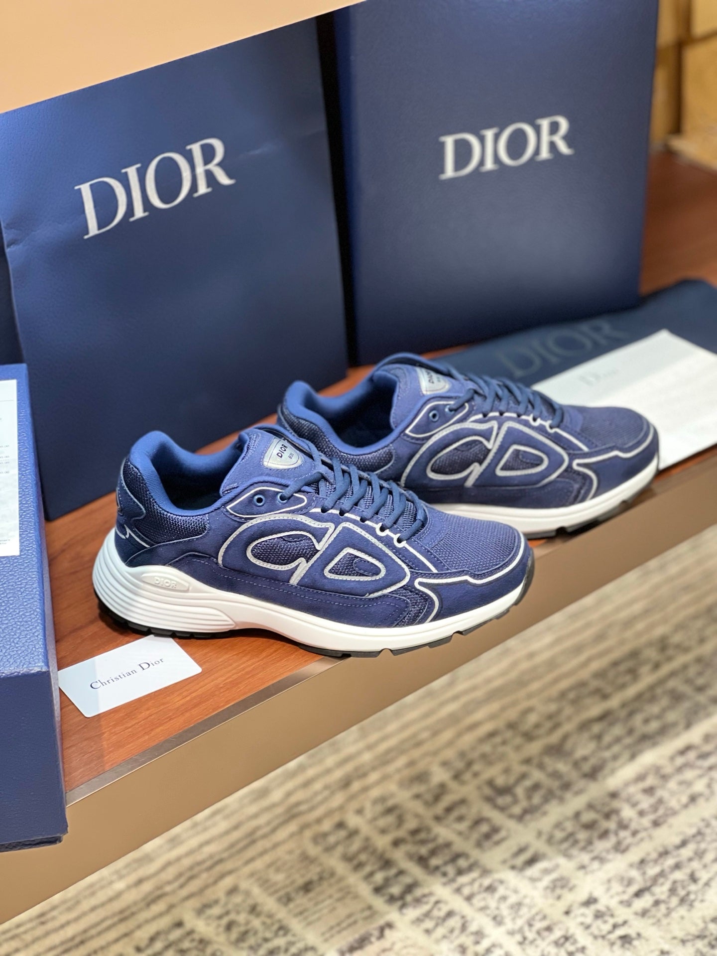Navy Dior lace-up sneakers with white soles and side logo detailing, angled view