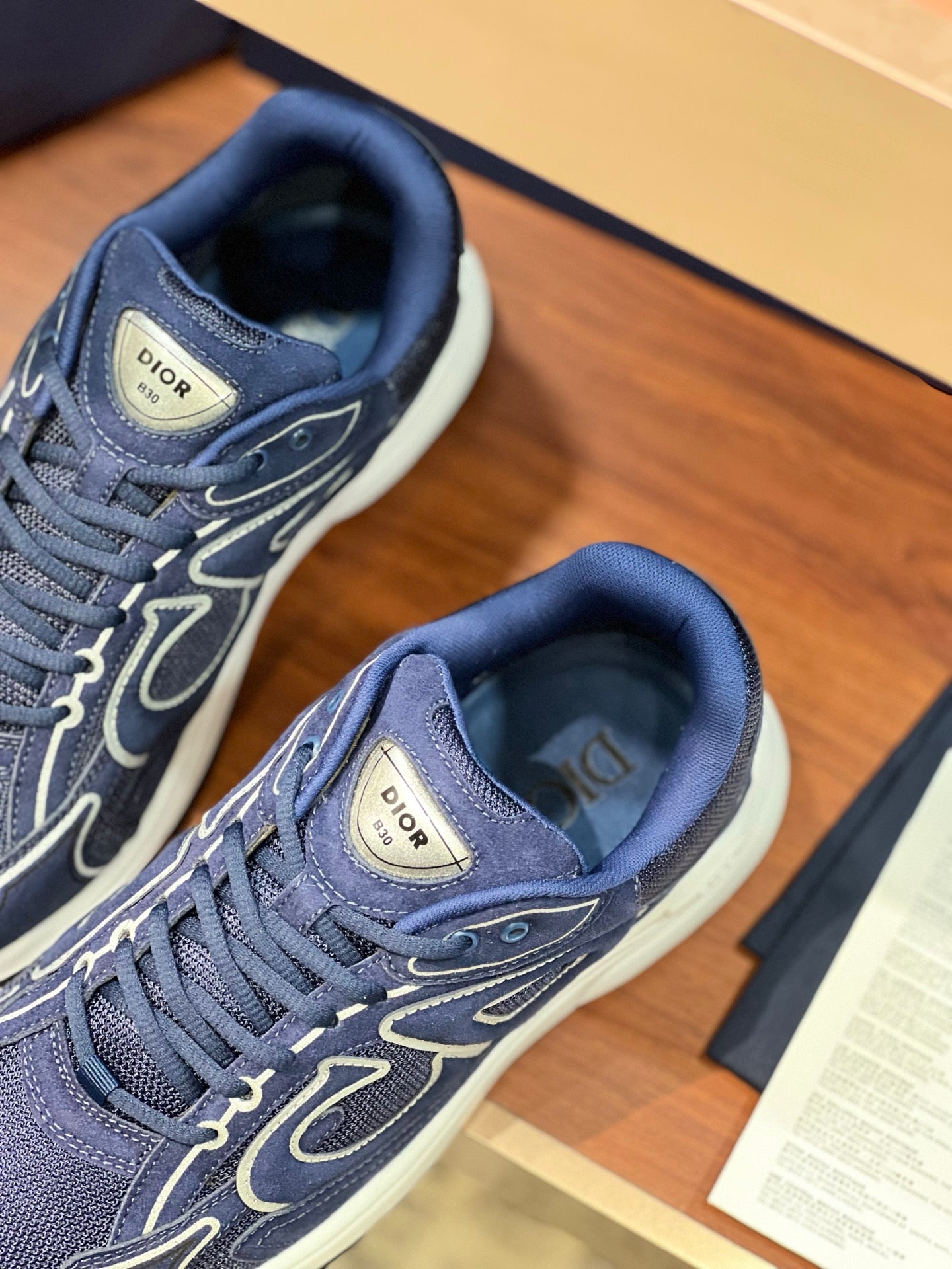 Navy Dior lace-up sneakers with textured uppers, visible laces and logo badge on tongue