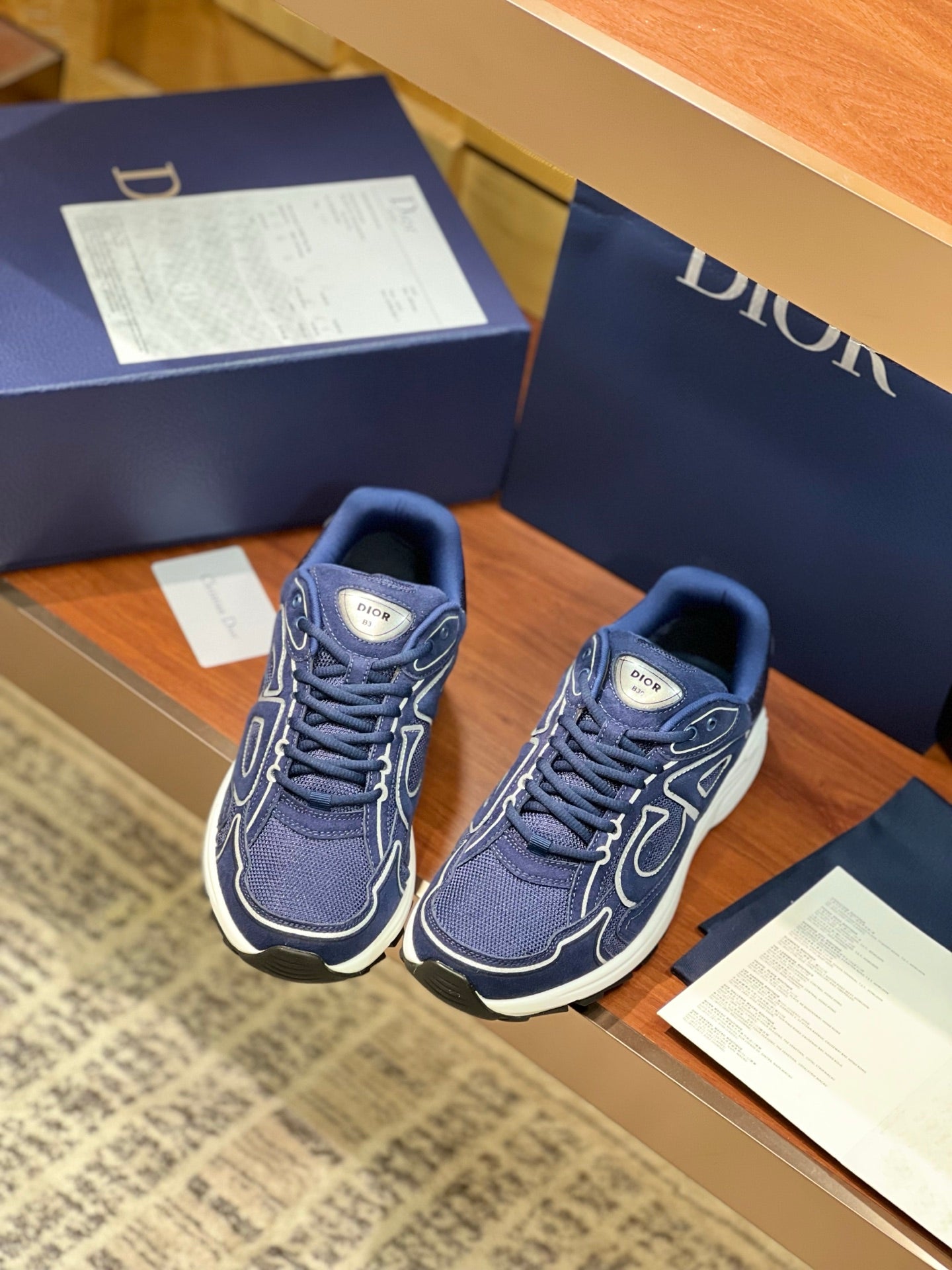 Navy Dior lace-up sneakers with white trim and logo embroidery, front 3/4 view