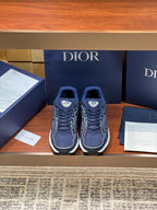 Navy Dior lace-up sneakers with white soles and curved logo detailing, side view