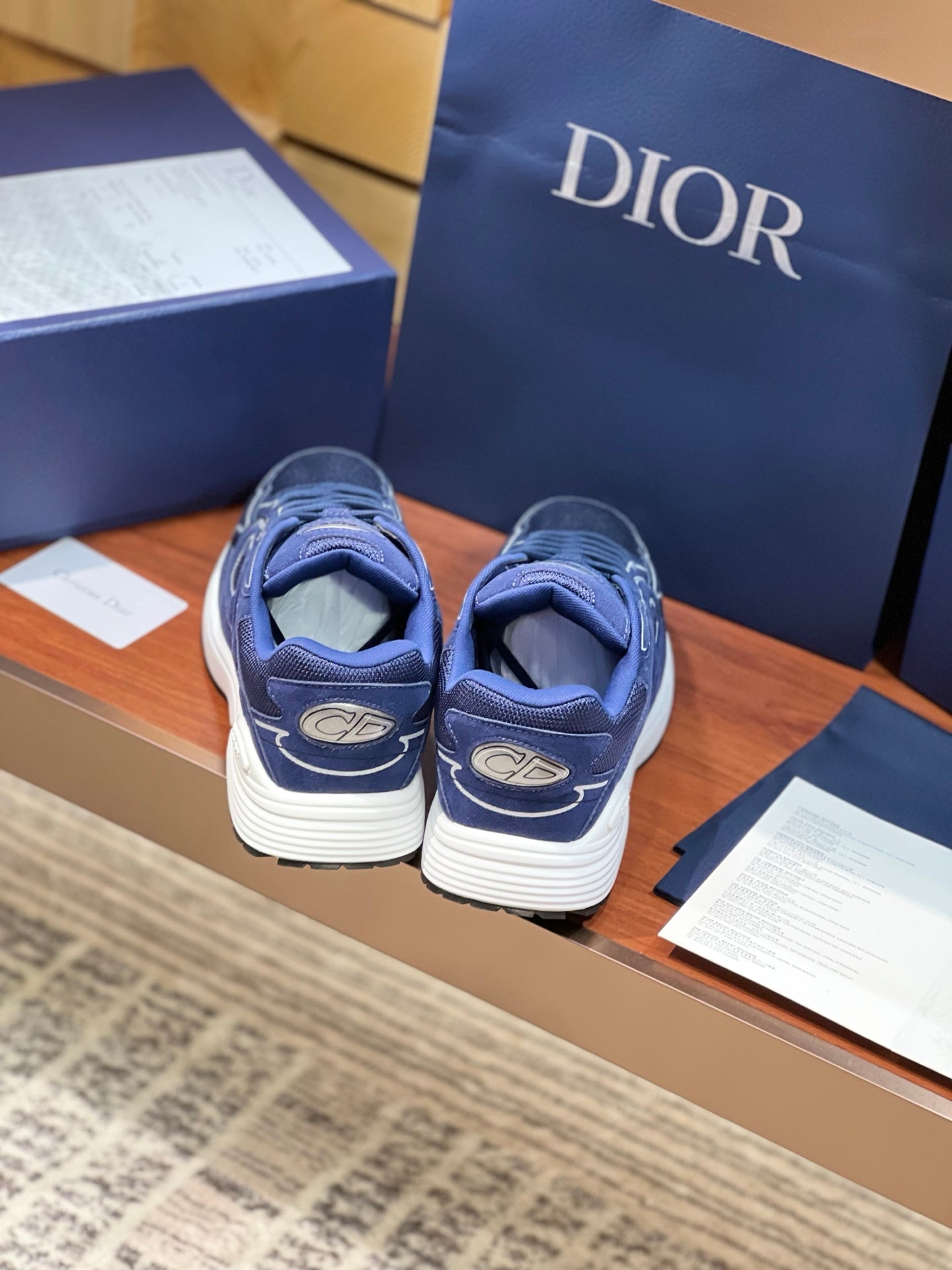 Navy Dior lace-up sneakers with white soles and logo on sides, rear view