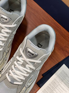 Close-up of ladies lace-up sneakers in light grey with Dior tongue patch