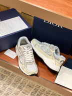 Pair of ladies lace-up sneakers in light beige and grey with side logos and laces