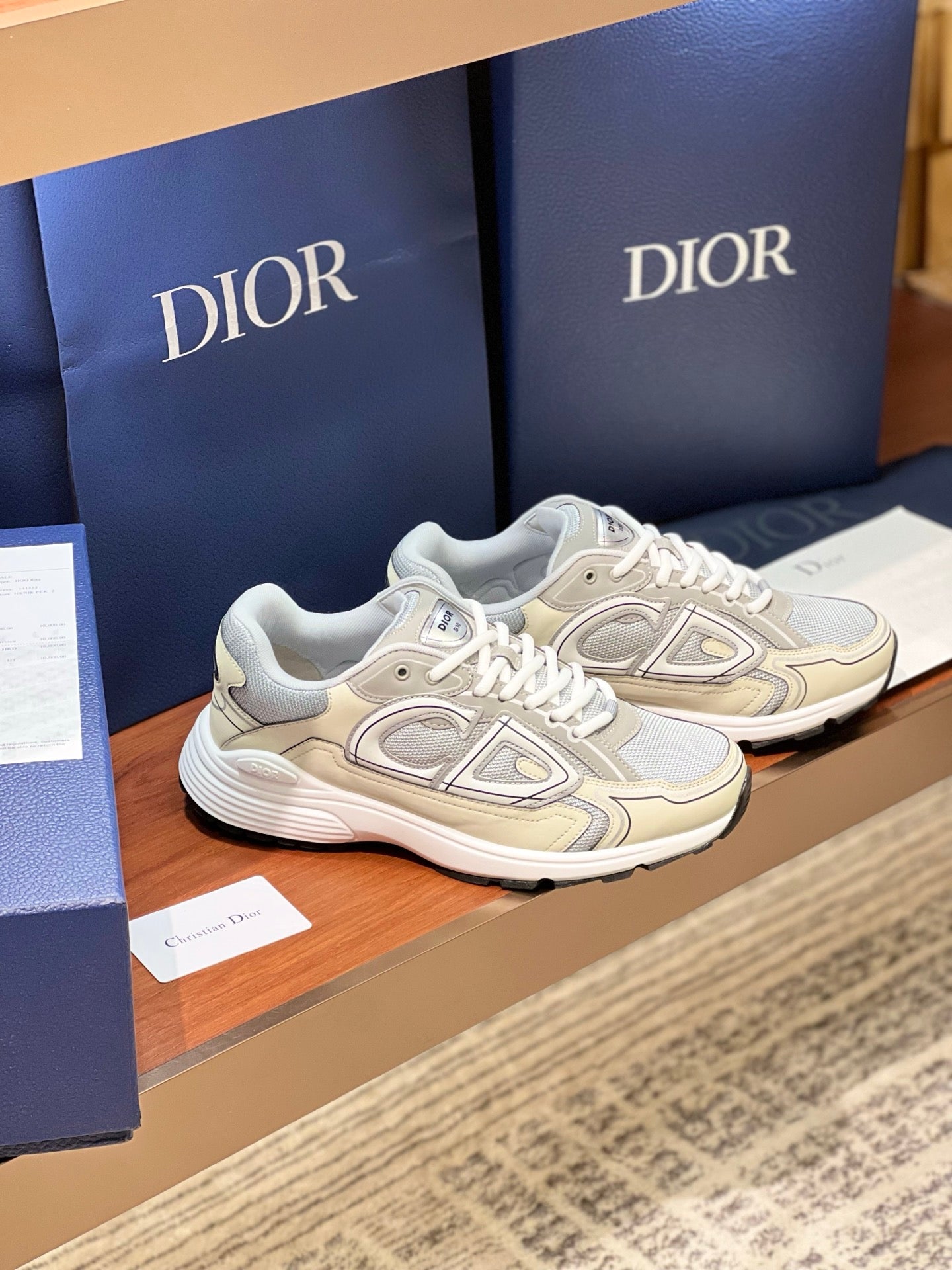 Ladies lace-up sneakers in light beige and grey, side profile with emblem design