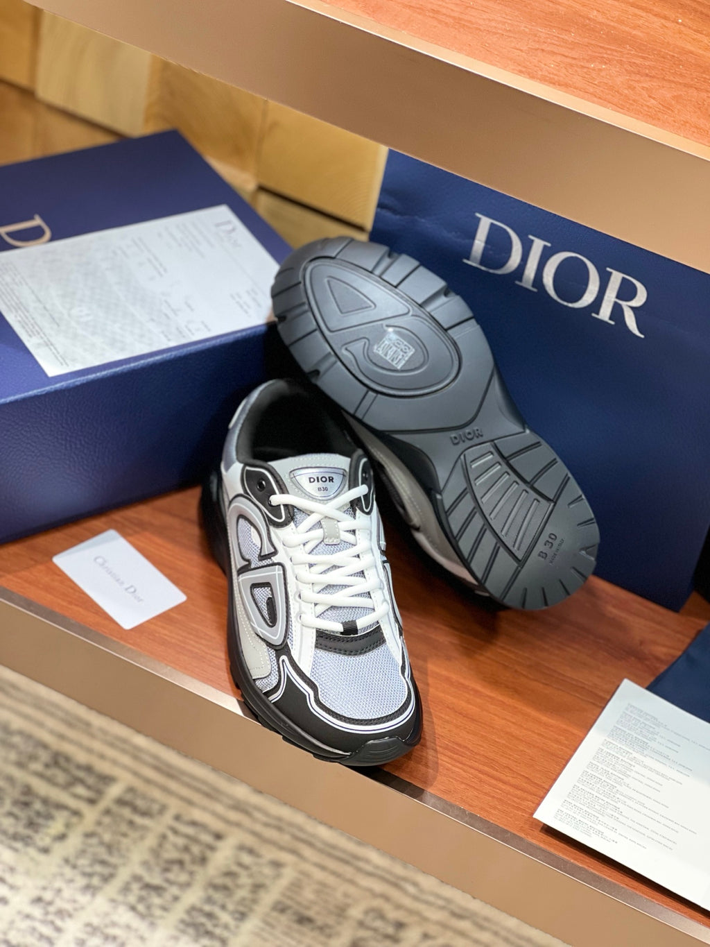 Dior low-top lace-up sneakers with tread sole visible, gray and black colorblock
