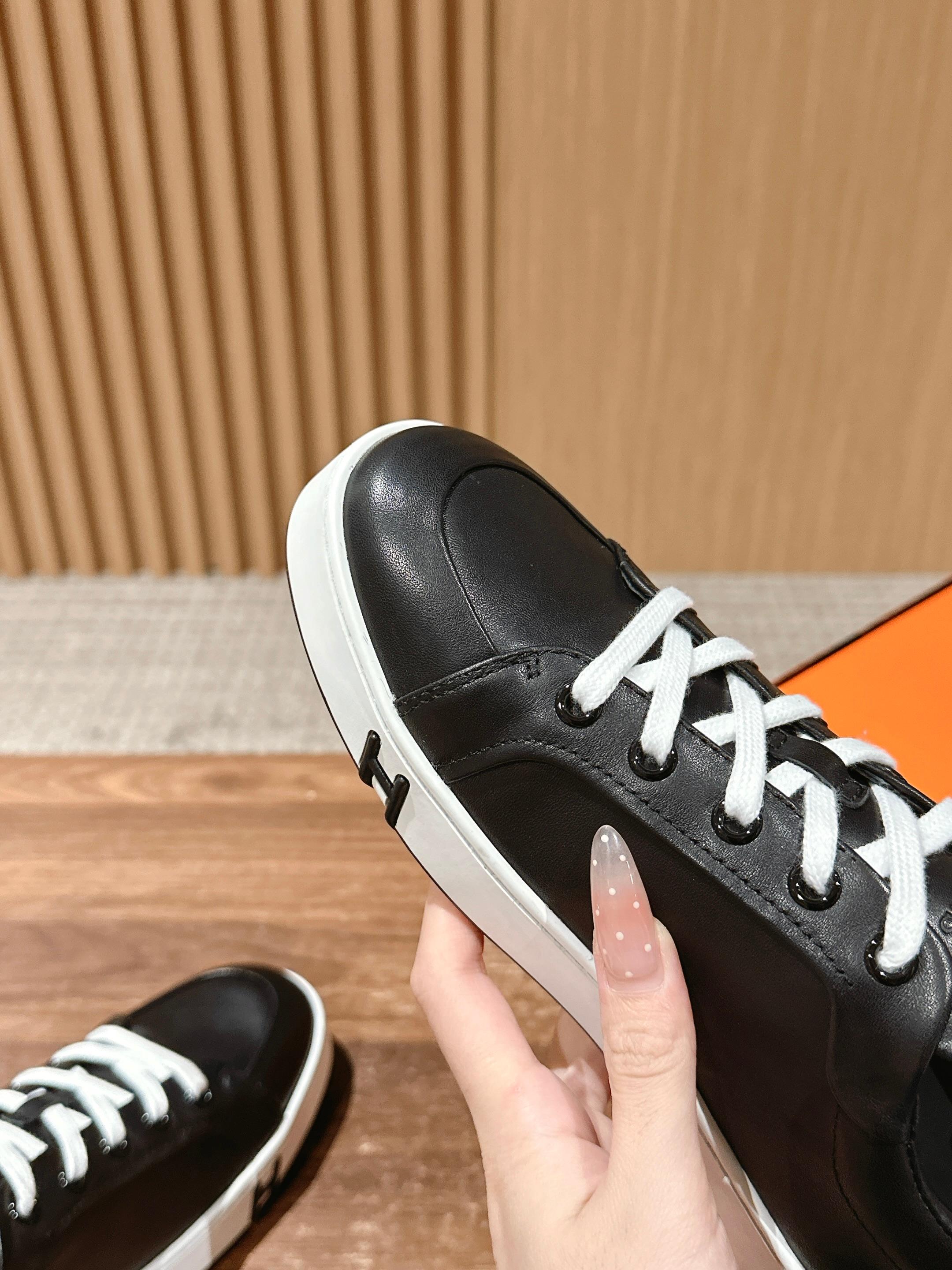 Hermes unisex black leather sneaker side view with white laces and thick white sole
