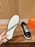 Hermes unisex black leather sneakers with treaded white outsole shown
