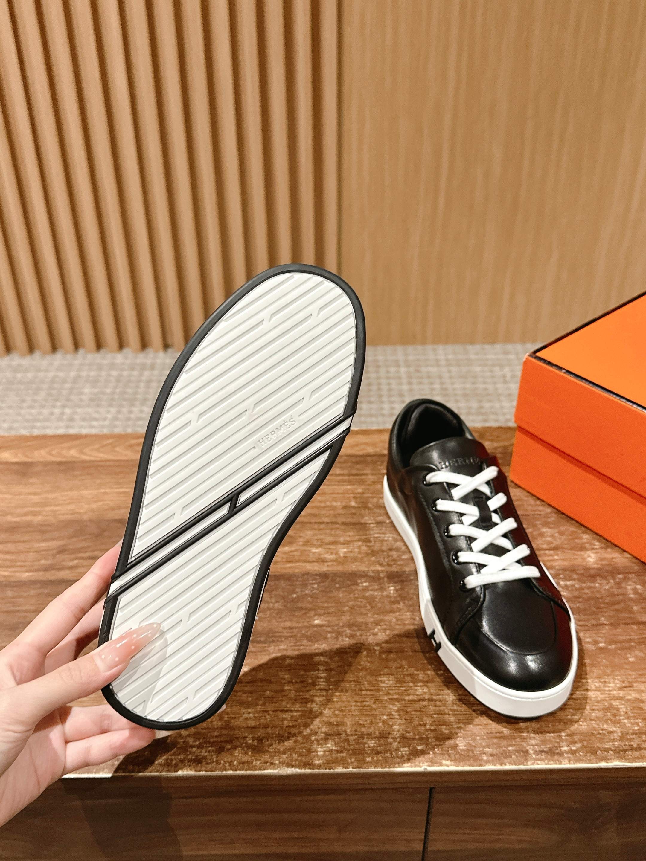 Hermes unisex black leather sneakers with treaded white outsole shown