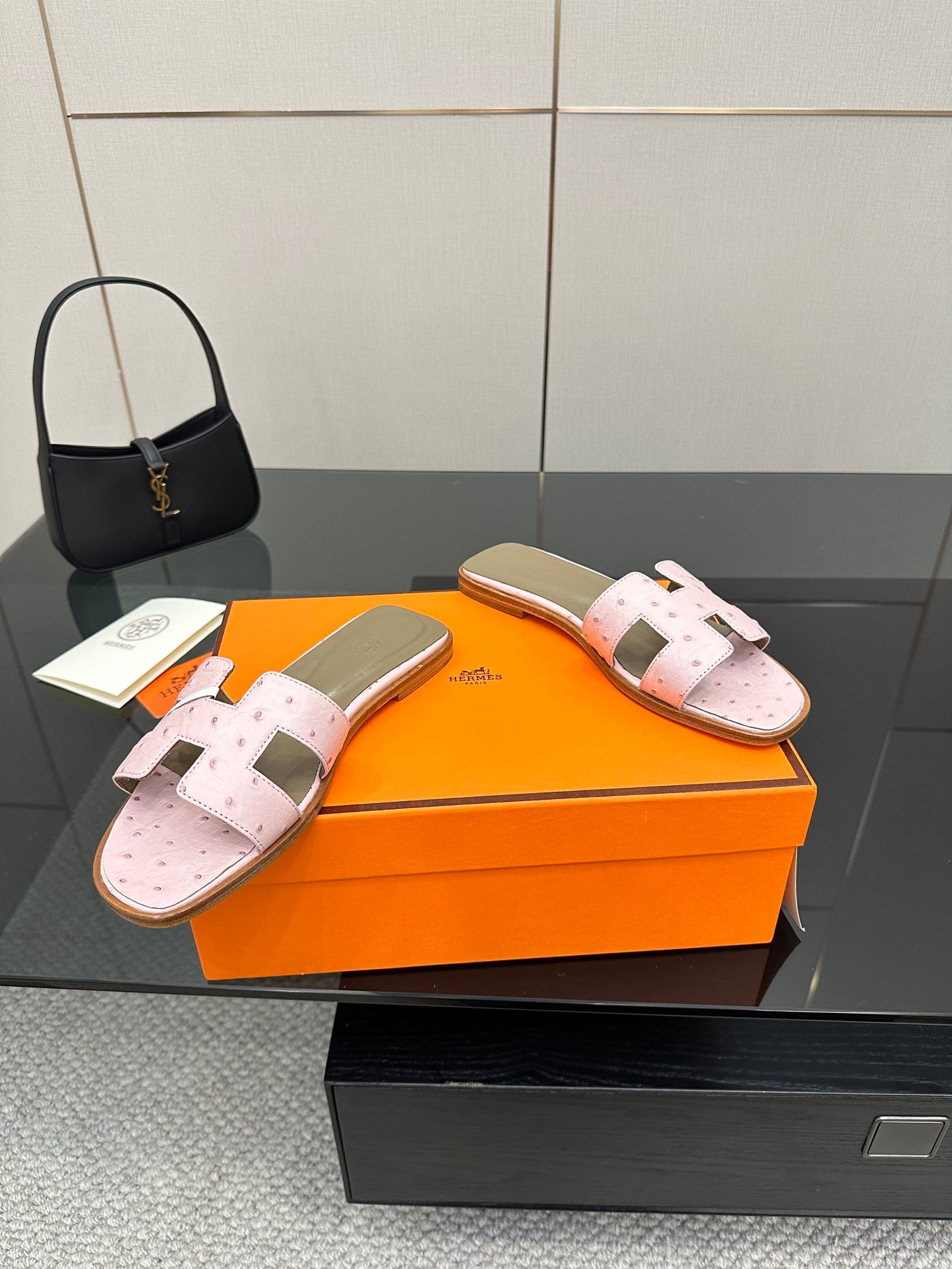 Ladies light pink leather slide sandals with perforations, wide straps, and open-toe design
