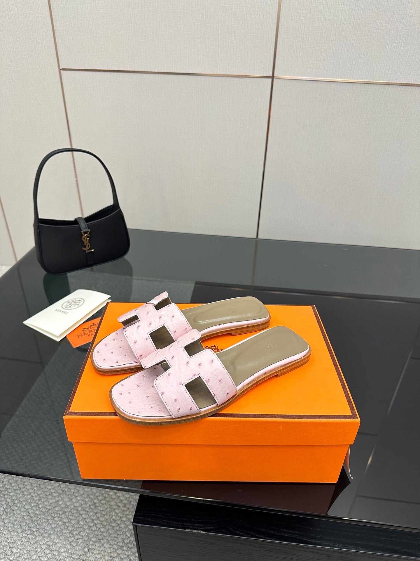 Ladies light pink leather slide sandals with wide straps and buckle-style hardware
