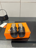 Black leather slide sandals with wide strap and gold-tone logo hardware