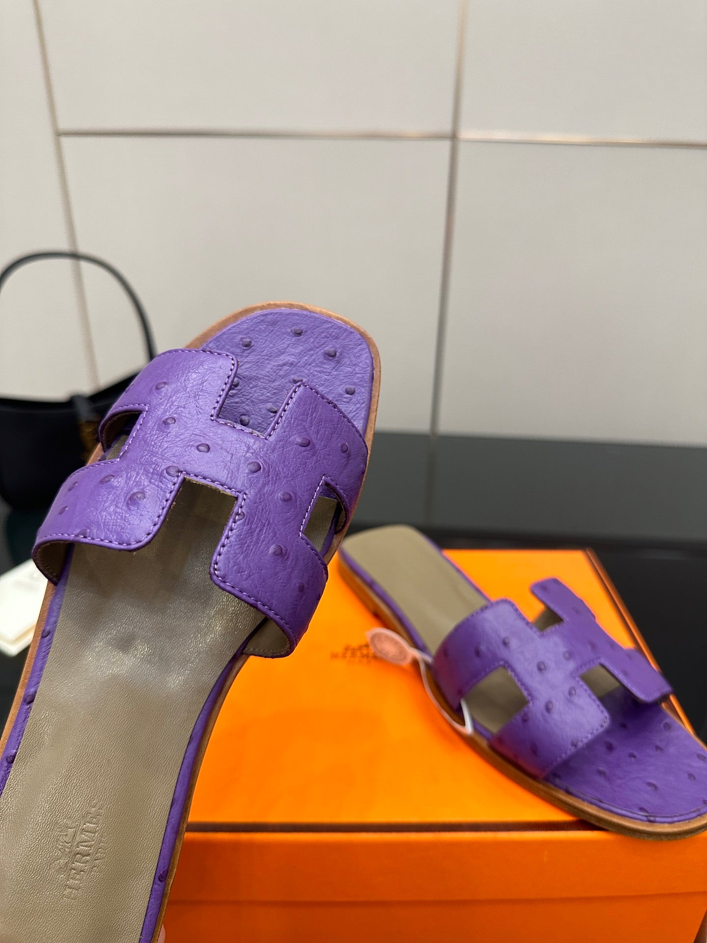 Hermes purple slide sandals, close-up of H-style cutout strap and stitched texture