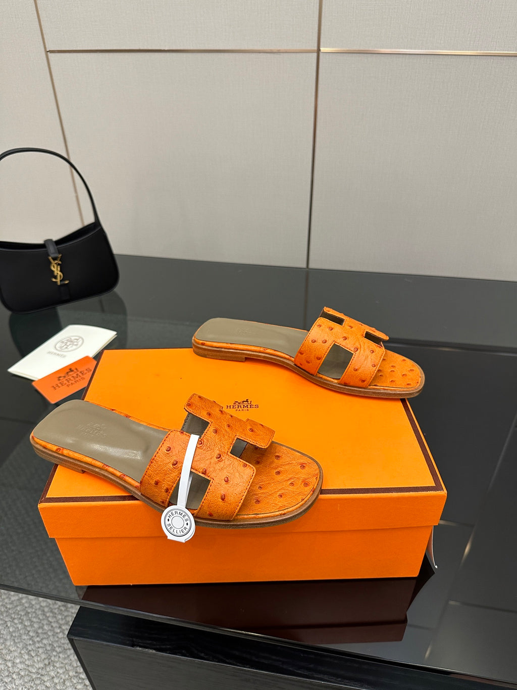 Orange leather slide sandals, one sandal front and one back with perforated straps