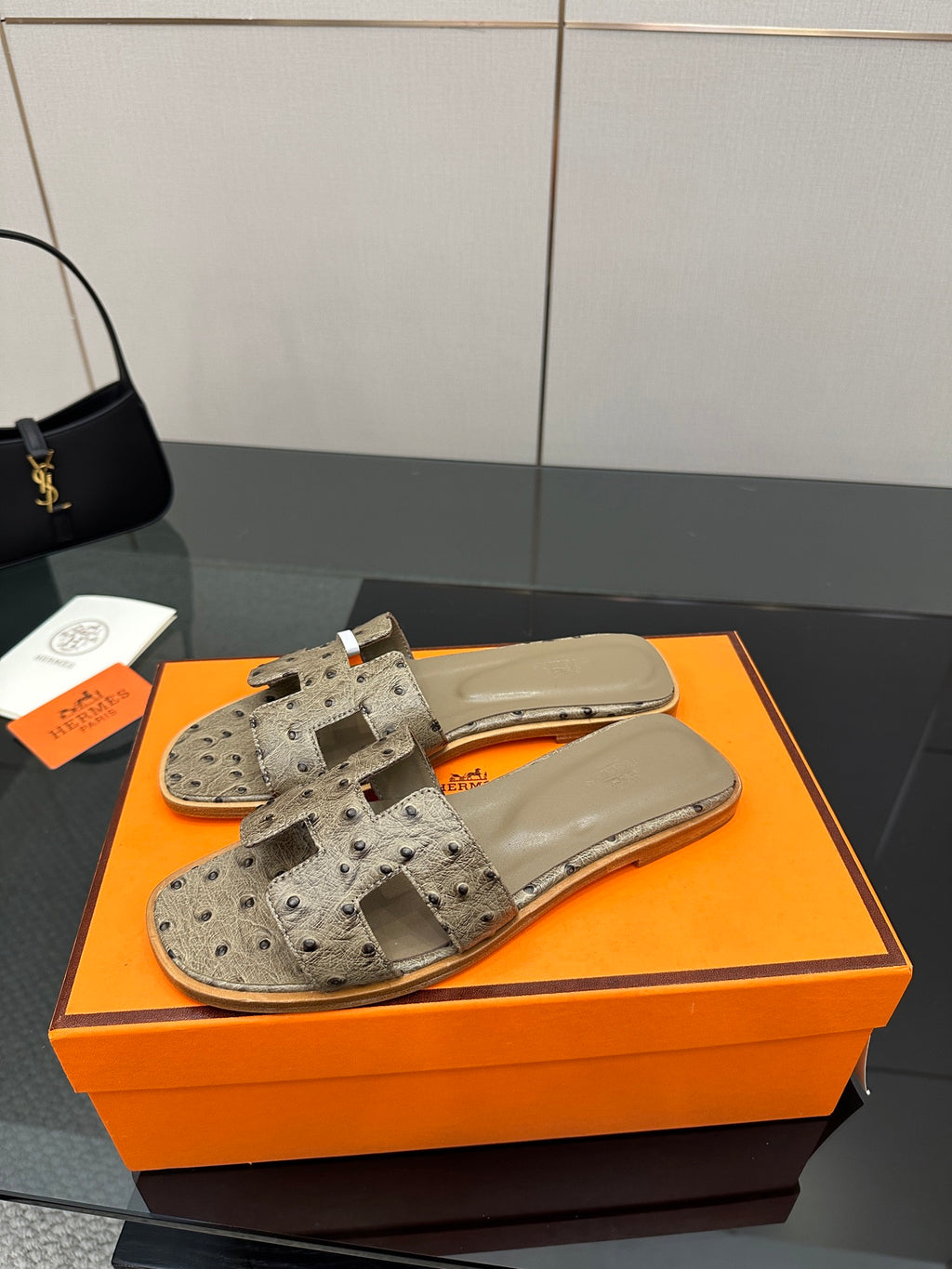 Hermes womens slide sandals in light gray, perforated texture with wide strap and open toe