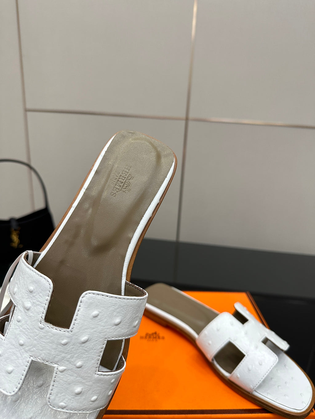 White leather slide sandal close-up showing open toe and side straps