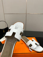 White leather slide sandal close-up with two straps and open toe