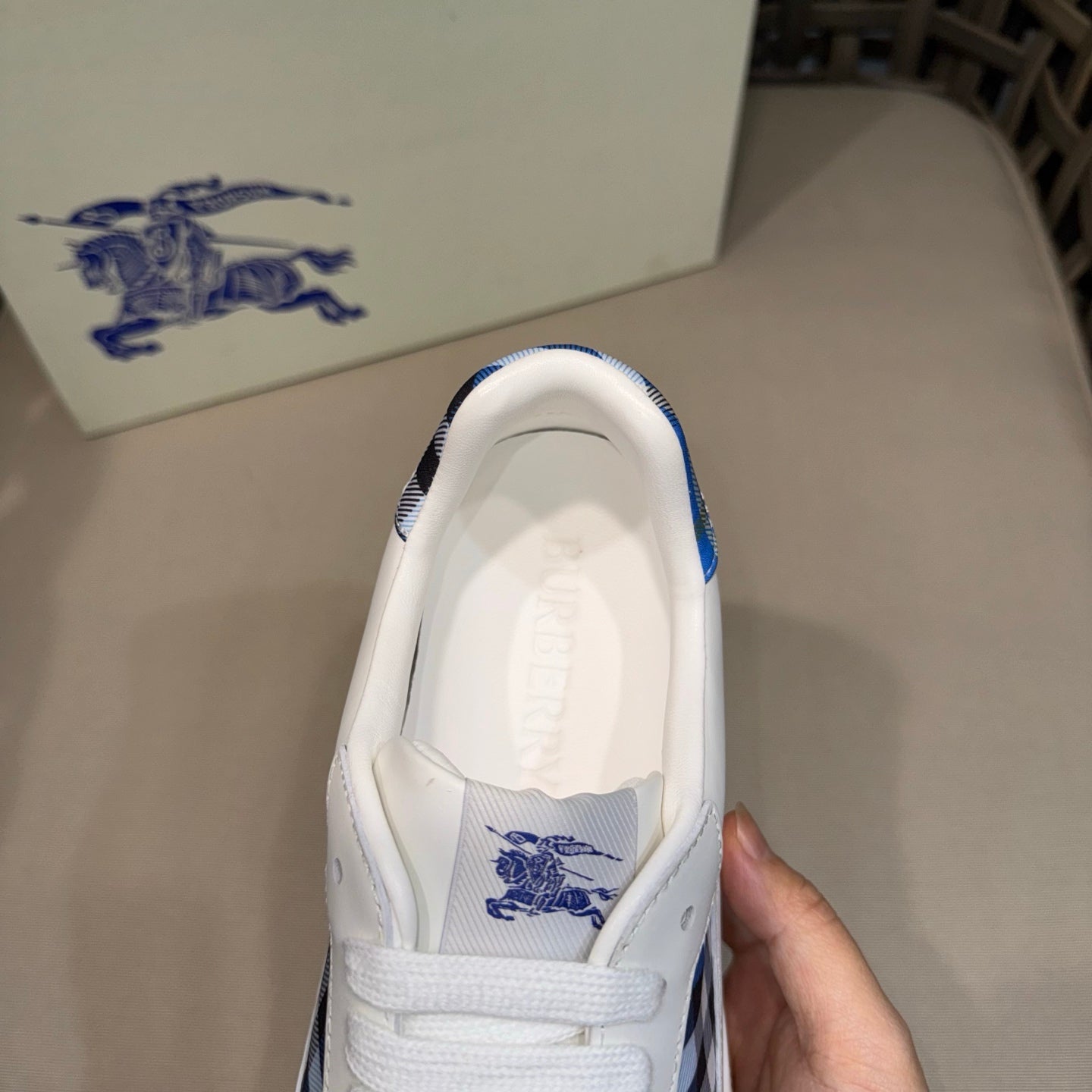Burberry white sneaker with blue-trimmed collar and logo on tongue