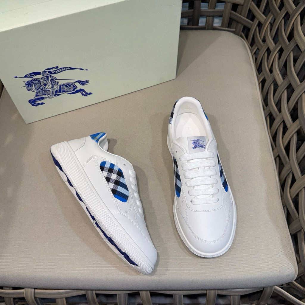 Burberry white sneakers, one shoe angled showing blue check insert