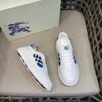 Burberry white sneakers, one shoe angled showing blue check insert