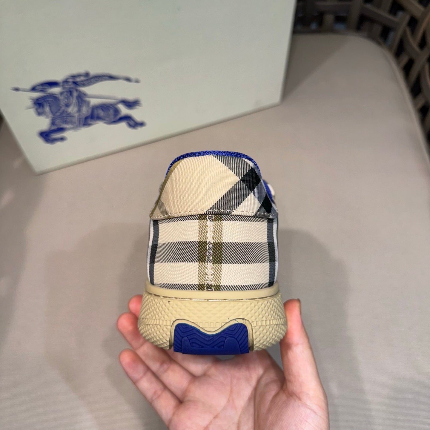 Sneaker heel view with beige check pattern and blue textured outsole detail