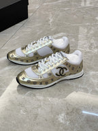 Unisex sneakers pair, white upper with gold logo panel and white rubber sole