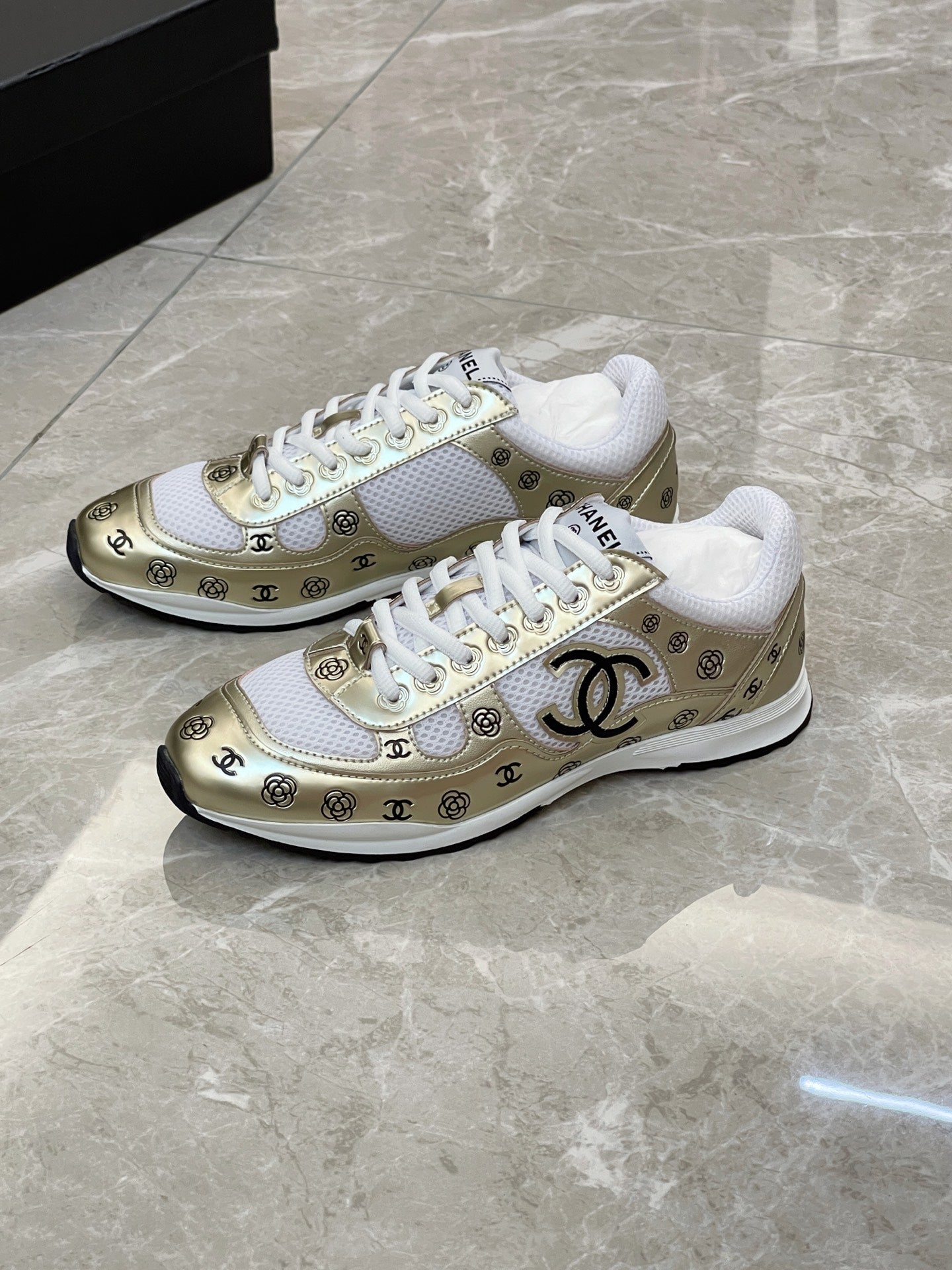 Unisex sneakers pair, white upper with gold logo panel and white rubber sole