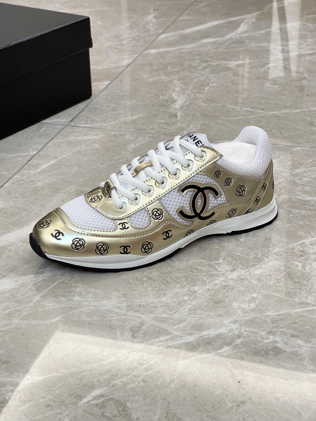 Unisex sneakers side view, white upper with gold logo trim and black outsole