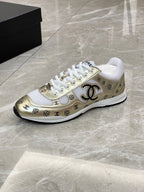 Unisex sneakers side view, white upper with gold logo trim and black outsole
