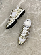 Unisex sneakers, white and gold uppers with logo pattern, on black soles