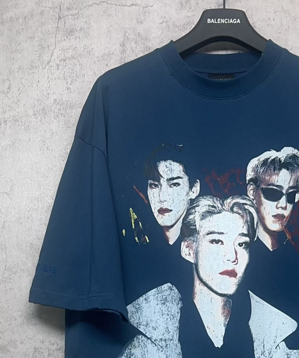 Blue graphic T-shirt with partial three-portrait print and faded lettering
