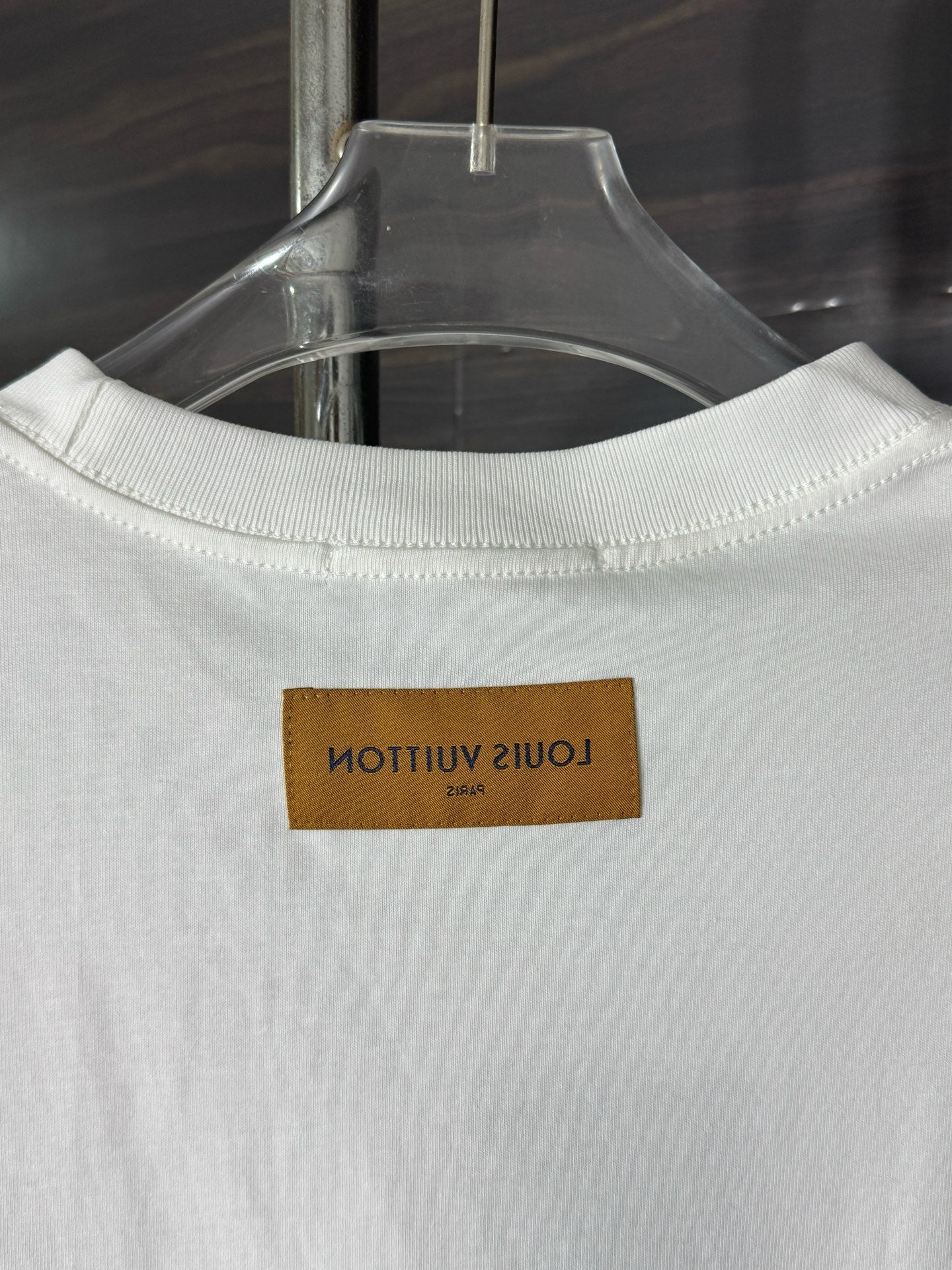 White crewneck T-shirt neckline with tan brand label