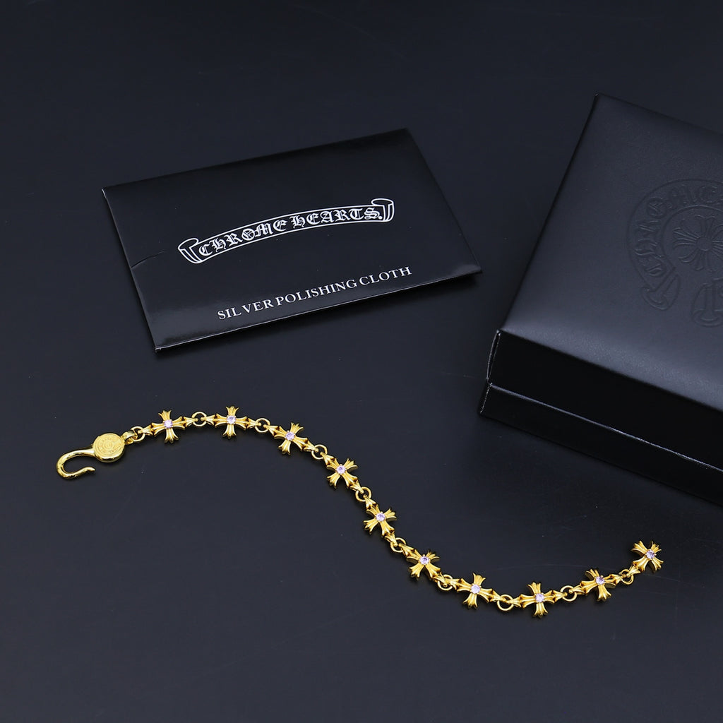 Gold charm bracelet with purple accents and a silver polishing cloth card