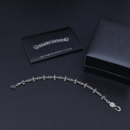 Silver charm bracelet with purple accents and a silver polishing cloth card