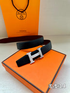 Navy leather belt with silver H buckle on orange presentation box.