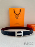 Navy leather belt with silver H buckle.