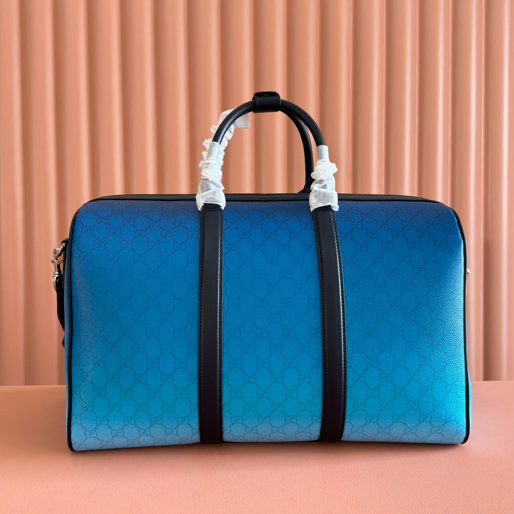 Gucci bag blue GG pattern with black center stripe and top handles.