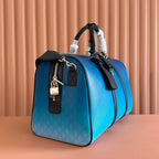 Gucci bag blue with GG pattern, black top handles, gold zipper pull and lock charm.