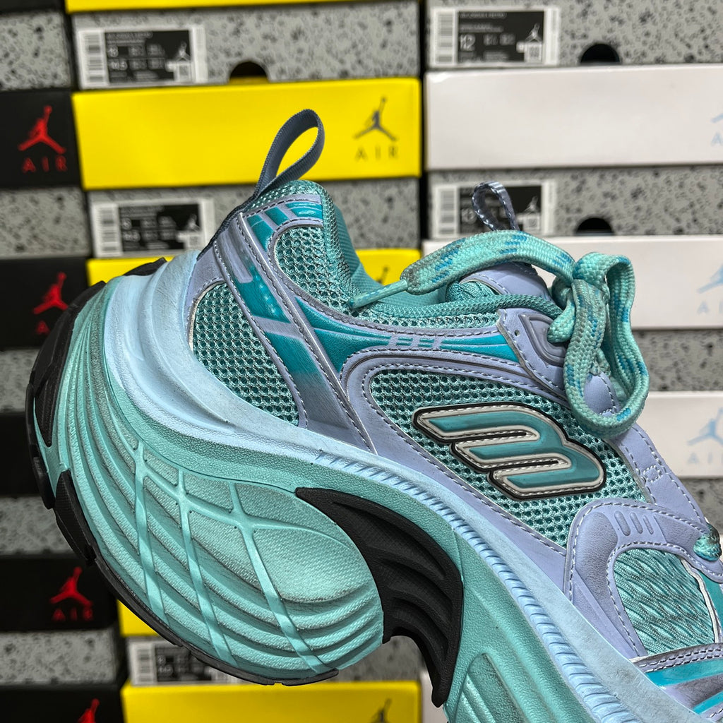 Teal and light blue athletic sneaker with lace-up closure and sculpted sole