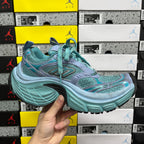 Teal and light blue athletic sneaker side profile with chunky midsole
