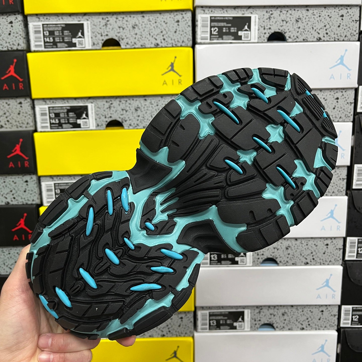 Black outsole with teal tread patterns for traction athletic sneaker
